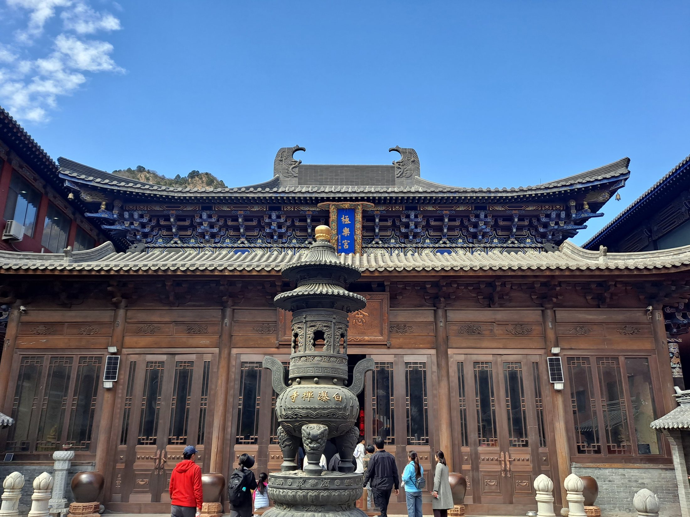 Colorful temple architecture at Baipu Temple in the Beijing mountains beneath a blue sky.