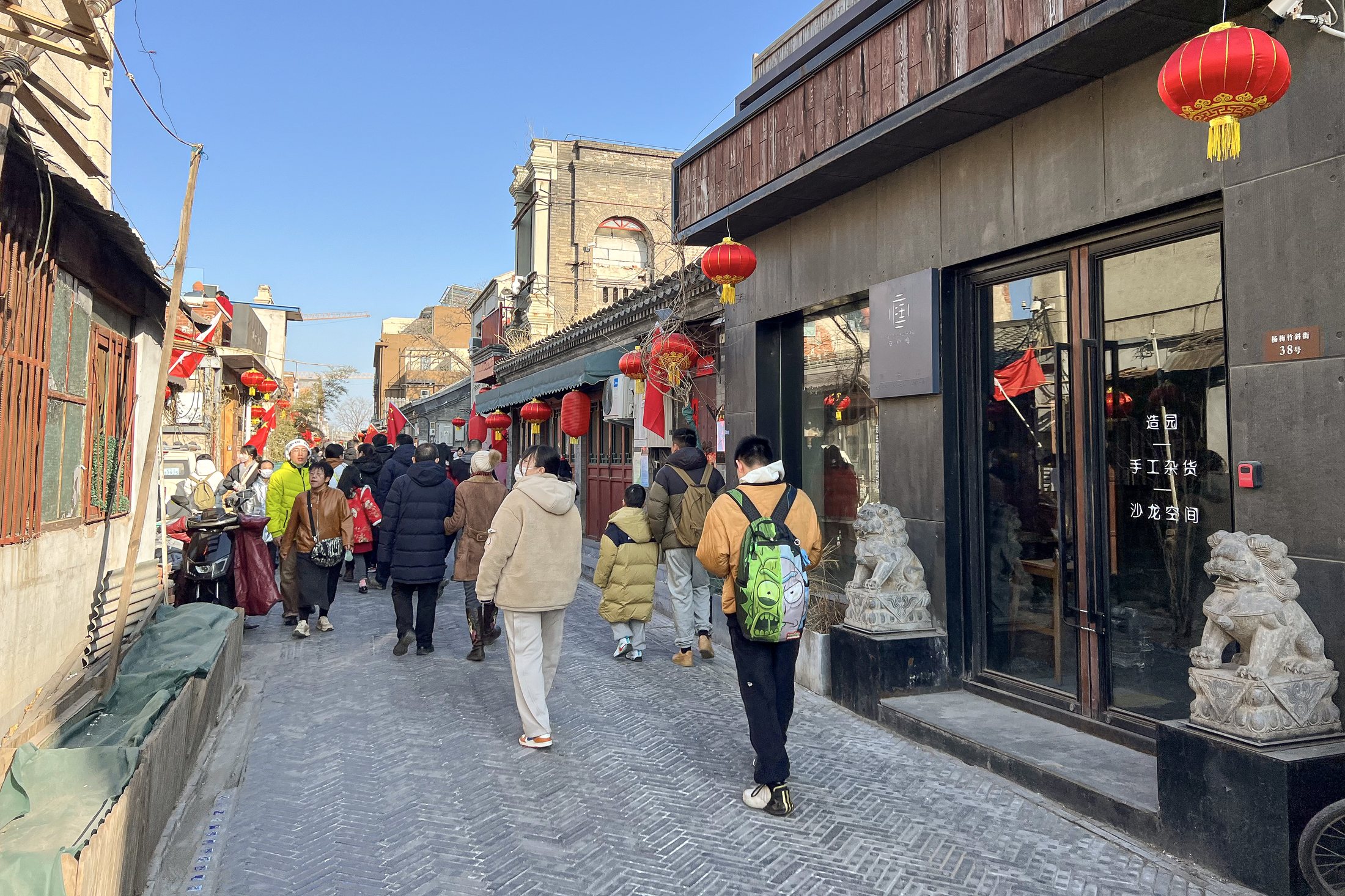 Historic low-rise storefronts and pedestrians along Yangmeizhu Xiejie in central Beijing.