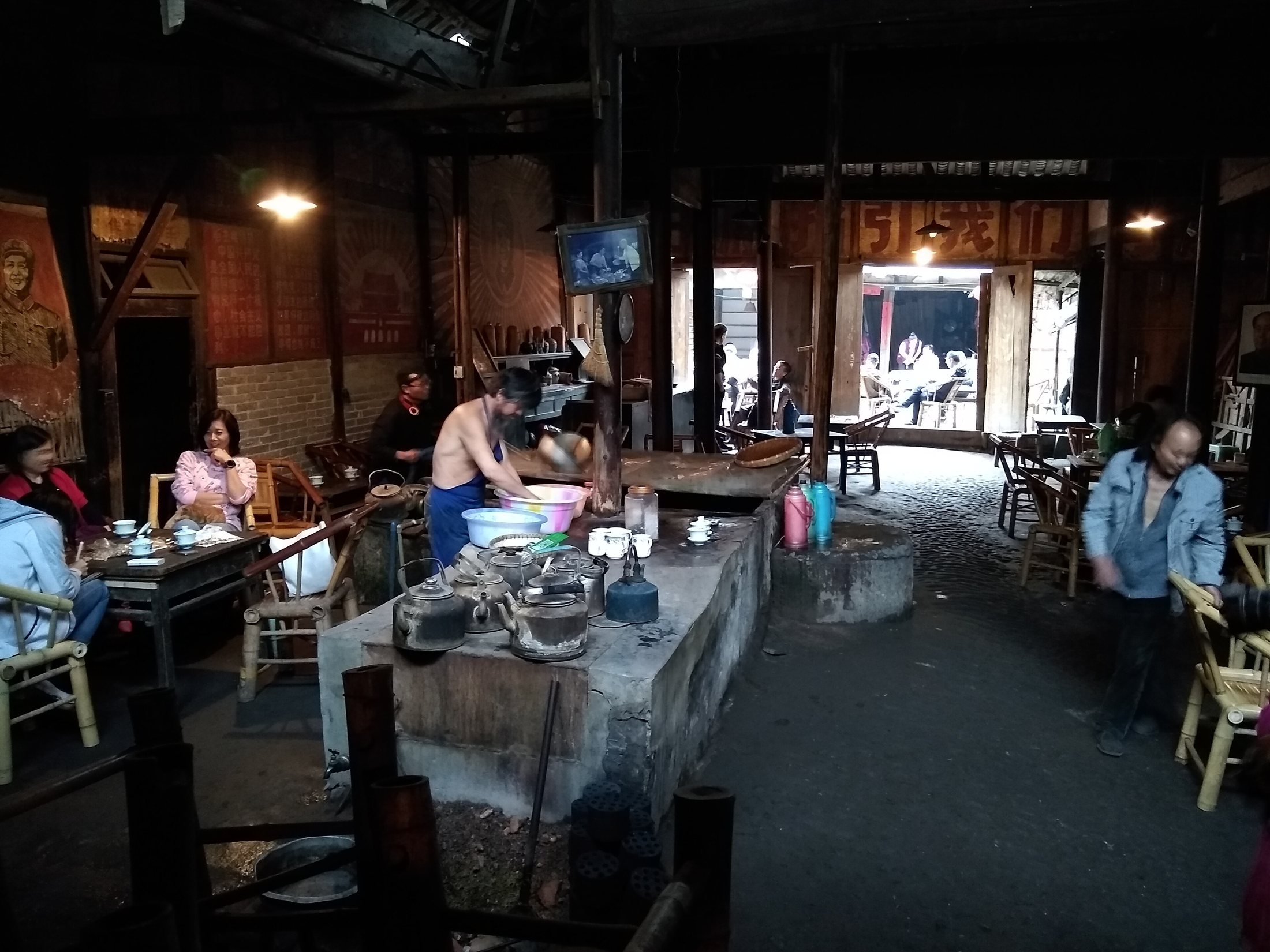Locals sitting in the atmospheric old wooden interior of Pengzhen Old Teahouse near Chengdu.