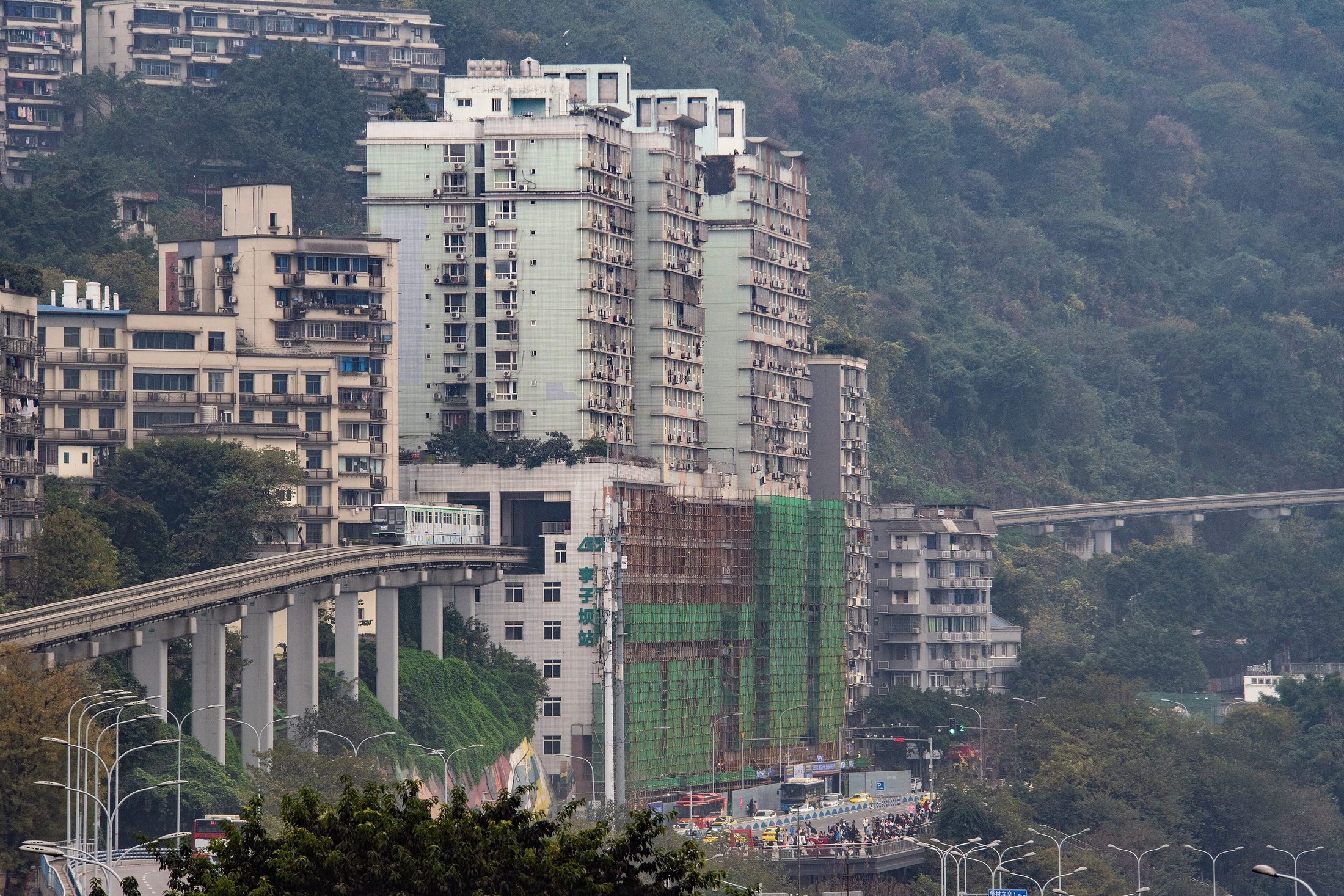 Dense residential towers and layered transit infrastructure in Chongqing that capture the vertical-city feel travelers associate with Baixiangju.