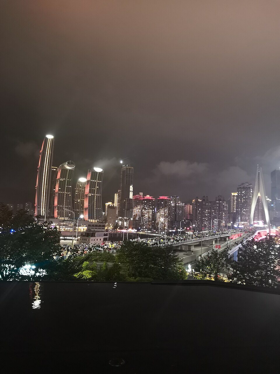 Chongqing's illuminated riverside skyline at night, the kind of view travelers seek on the Two Rivers Cruise.