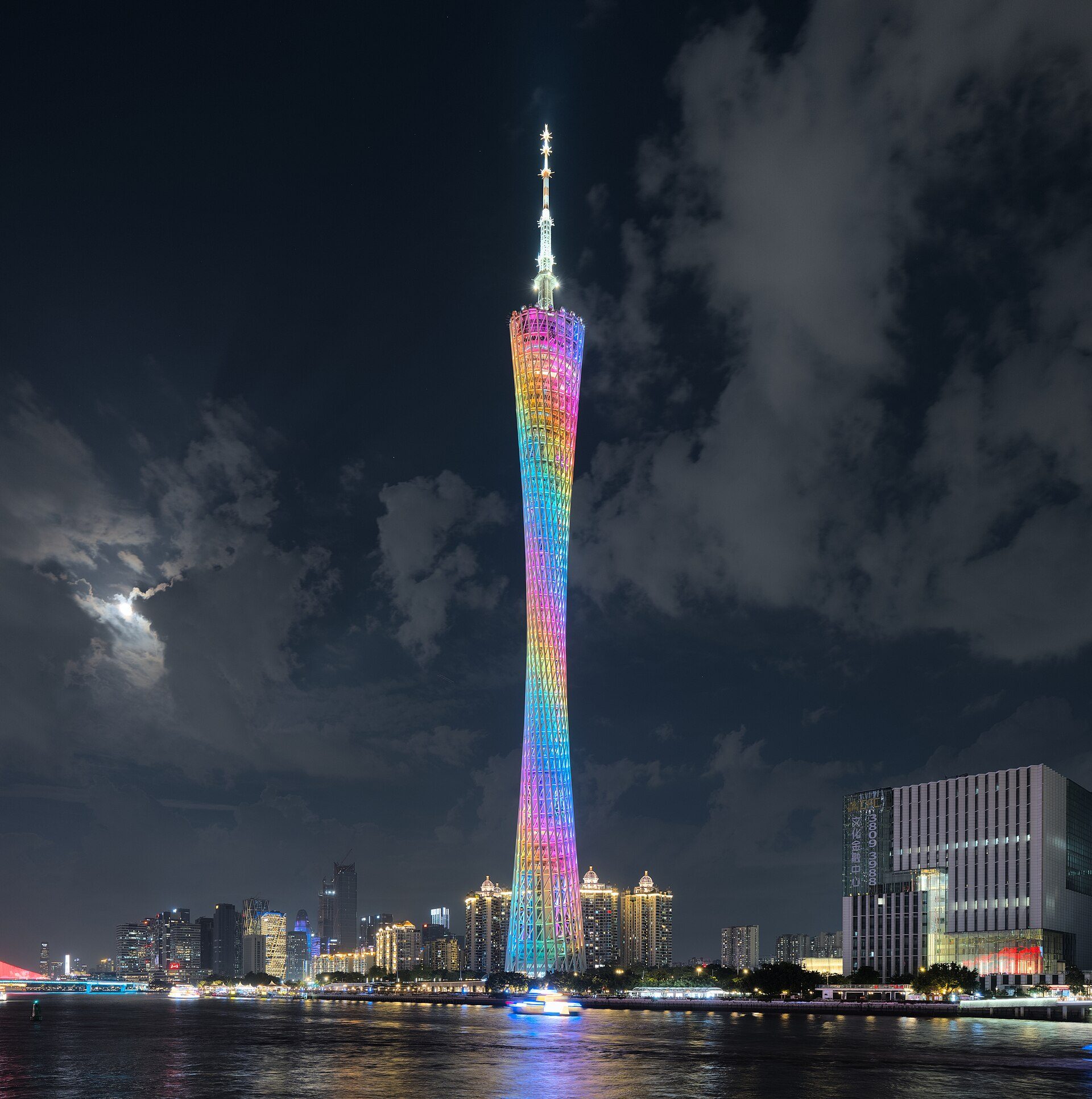 Canton Tower lit in rainbow colors above the Pearl River skyline in Guangzhou at night.