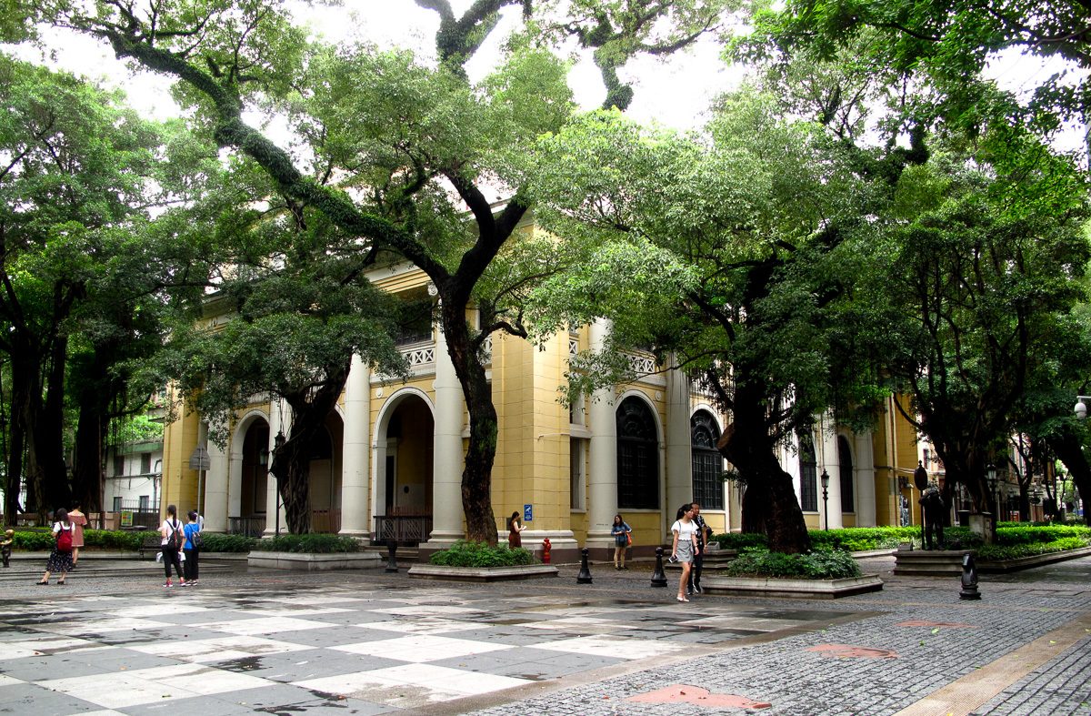 A colonial-era building shaded by large banyan trees on Shamian Island in Guangzhou.