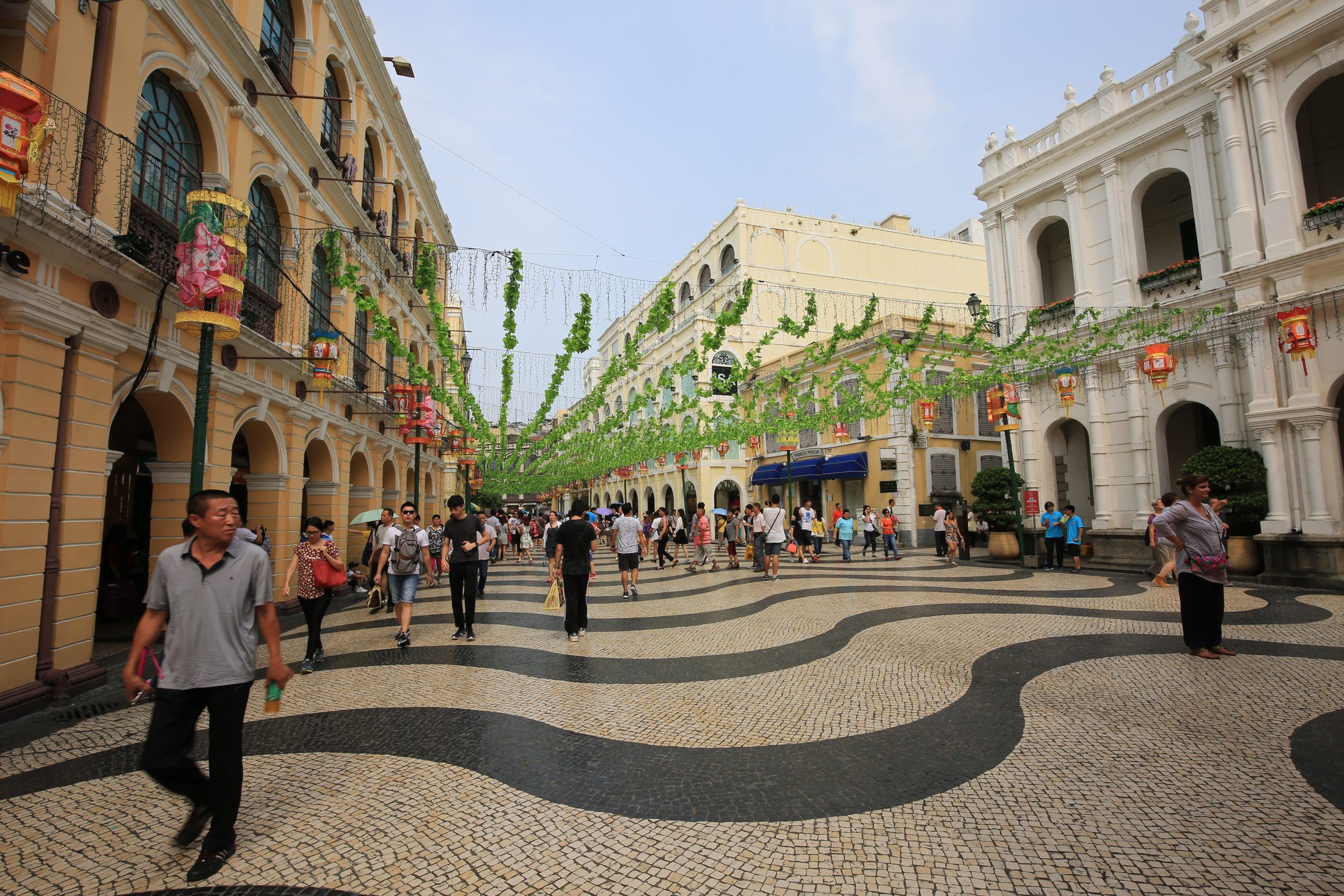 Senado Square in Macau with its wave-pattern pavement, pastel arcades, and busy daytime foot traffic.