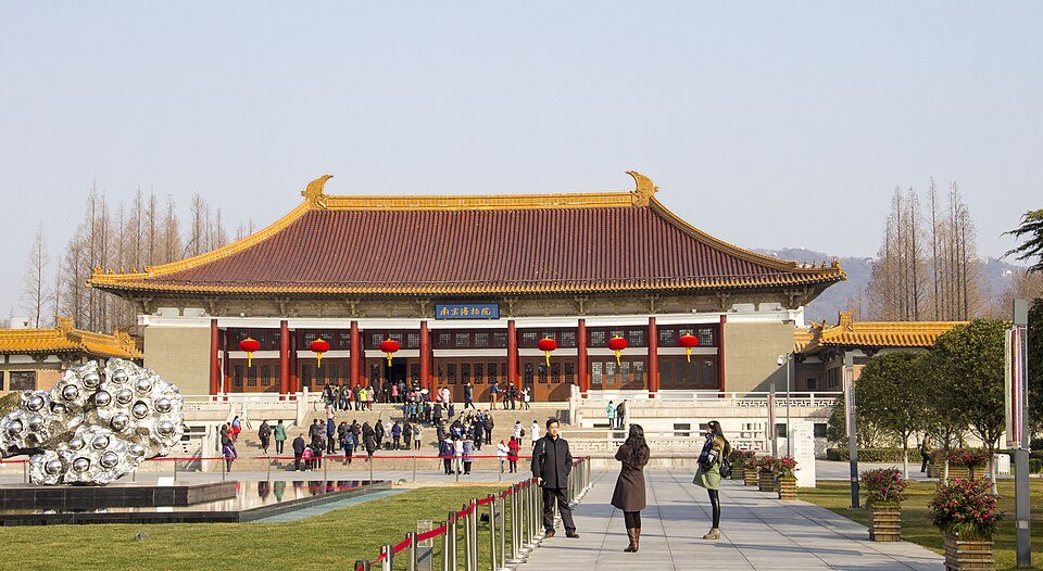 The main building of Nanjing Museum with broad steps and classical architecture under blue sky.