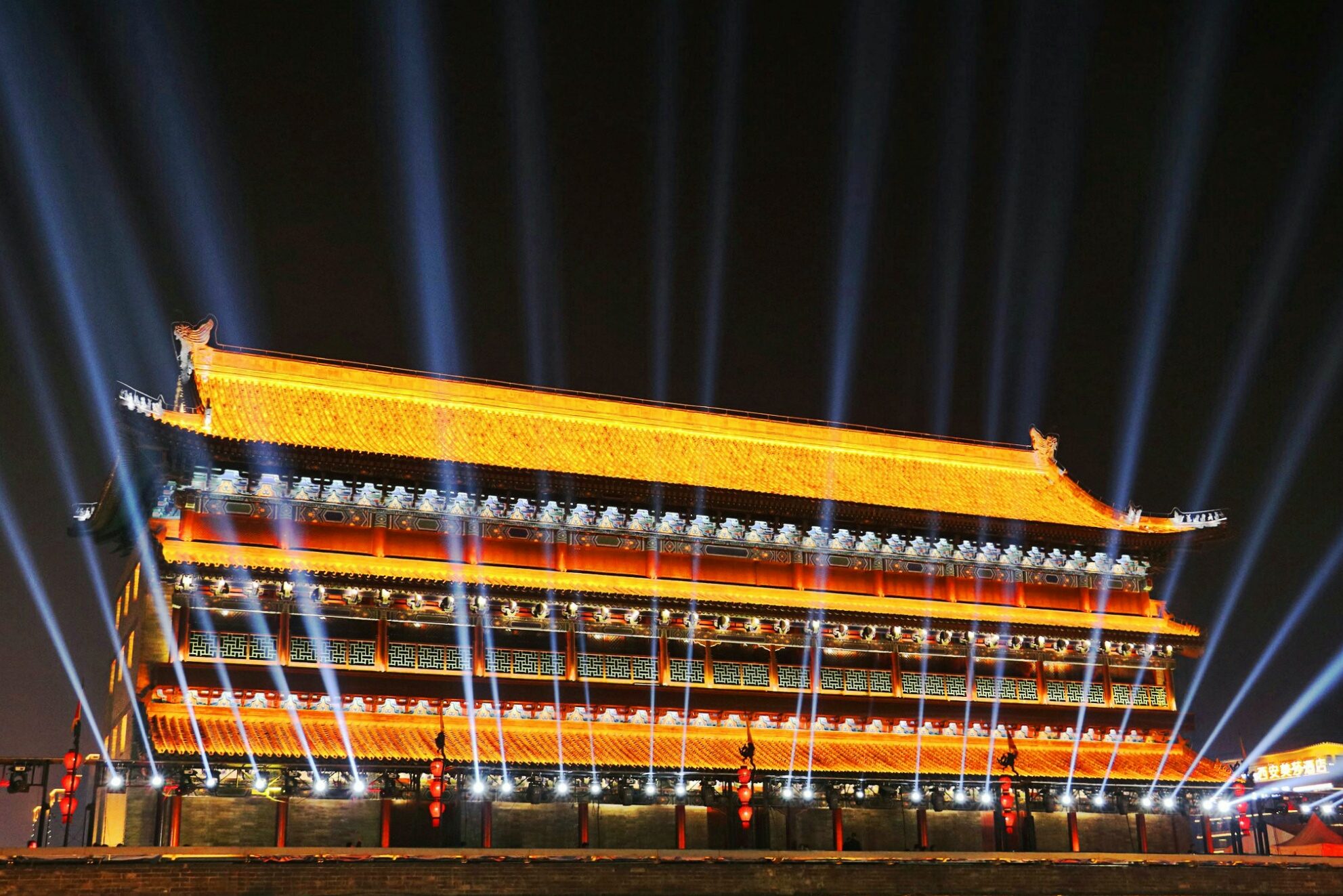 Illuminated South Gate of Xi'an at night with bright light beams above the historic gate tower.