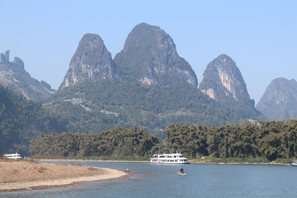 Classic Li River scenery at Xingping with karst peaks, boats, and clear reflective water.