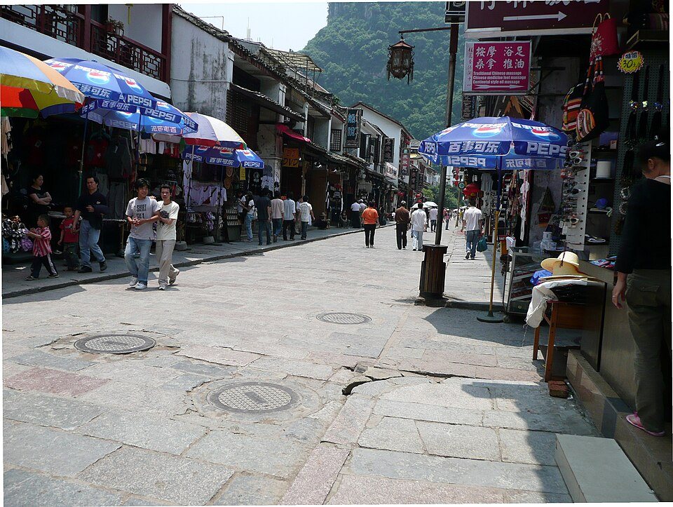 The busy pedestrian atmosphere of West Street in Yangshuo framed by karst-country travel energy.