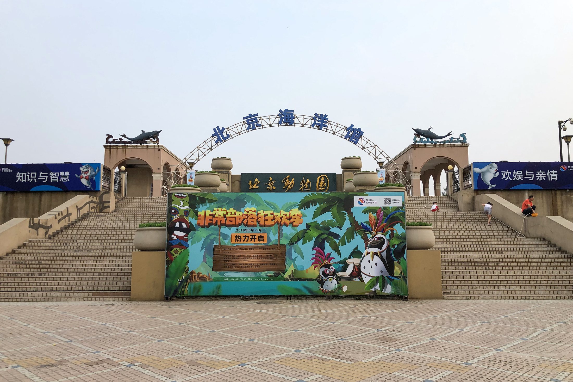 The main entrance area of Beijing Aquarium on a bright summer day.