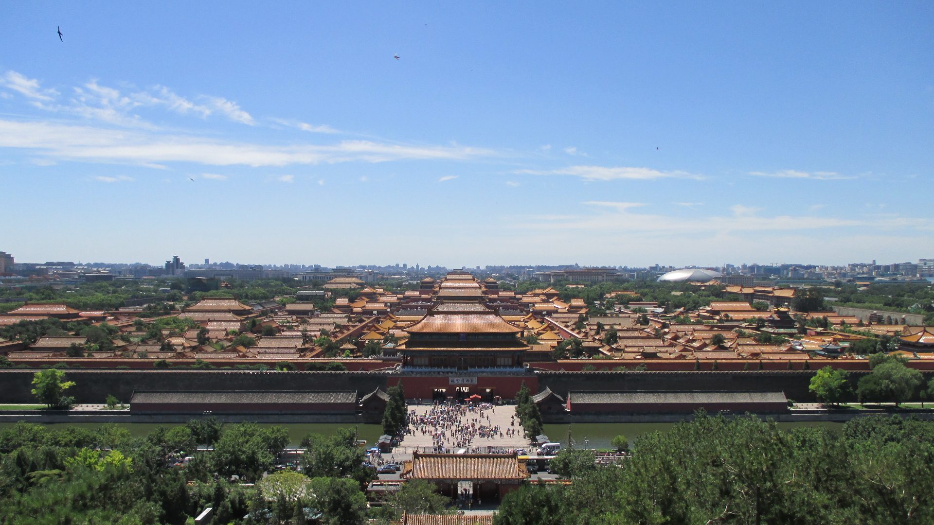 View from Jingshan Park over the Forbidden City rooftops and central Beijing under a clear blue sky.