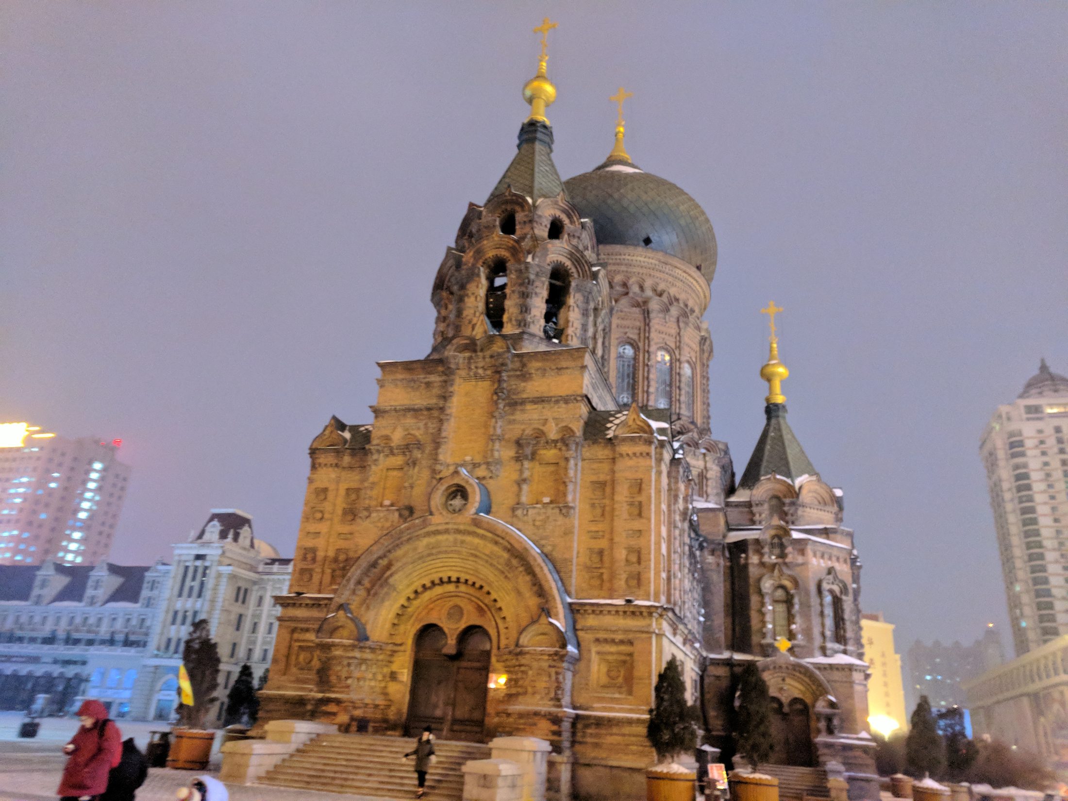 Saint Sophia Cathedral in Harbin glowing against a snowy evening sky.