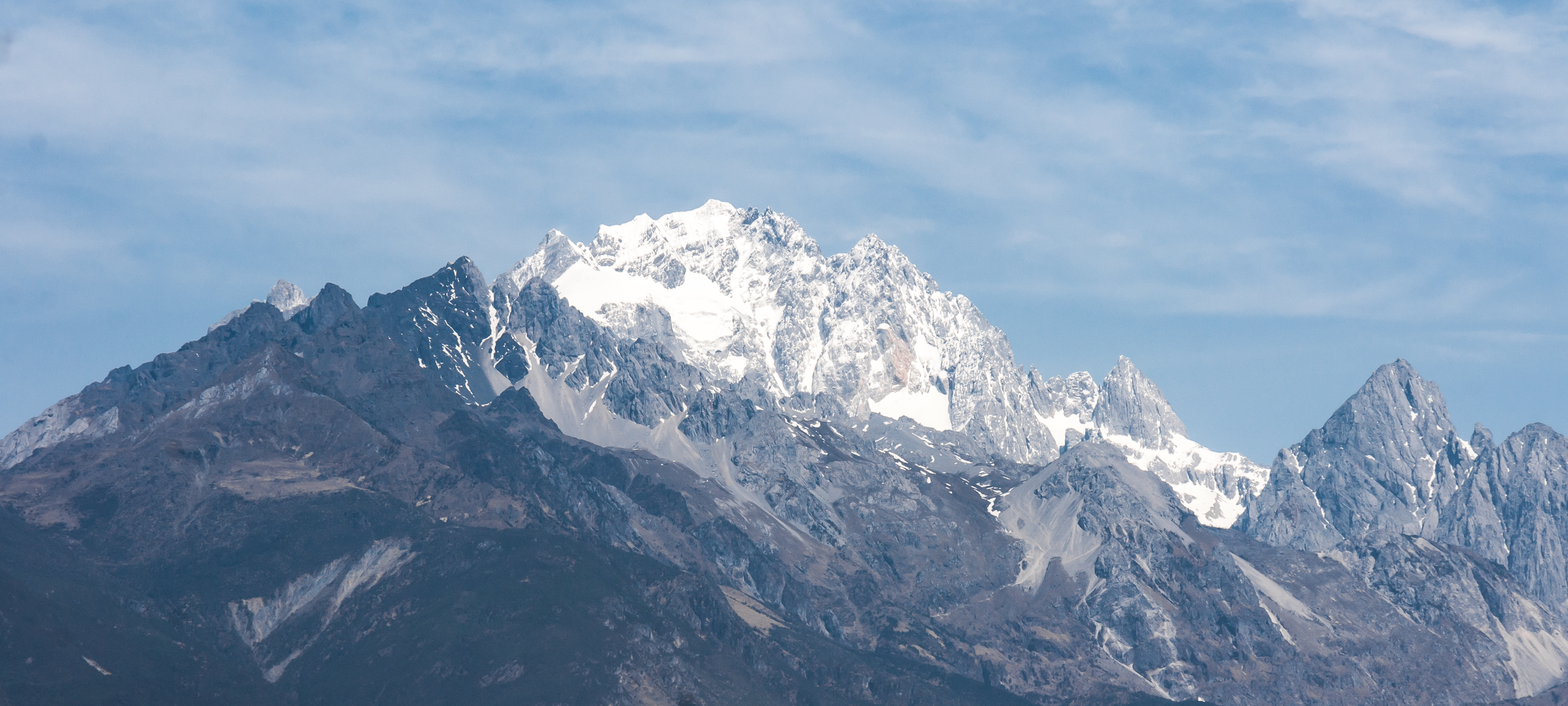 Jade Dragon Snow Mountain rising above Lijiang, cold and detached, giving the whole basin a sense of altitude and unfinished ascent.