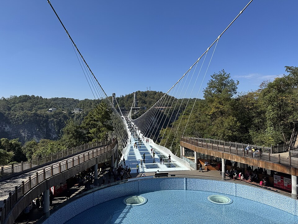 The Zhangjiajie Grand Canyon Glass Bridge stretching across a dramatic green gorge.